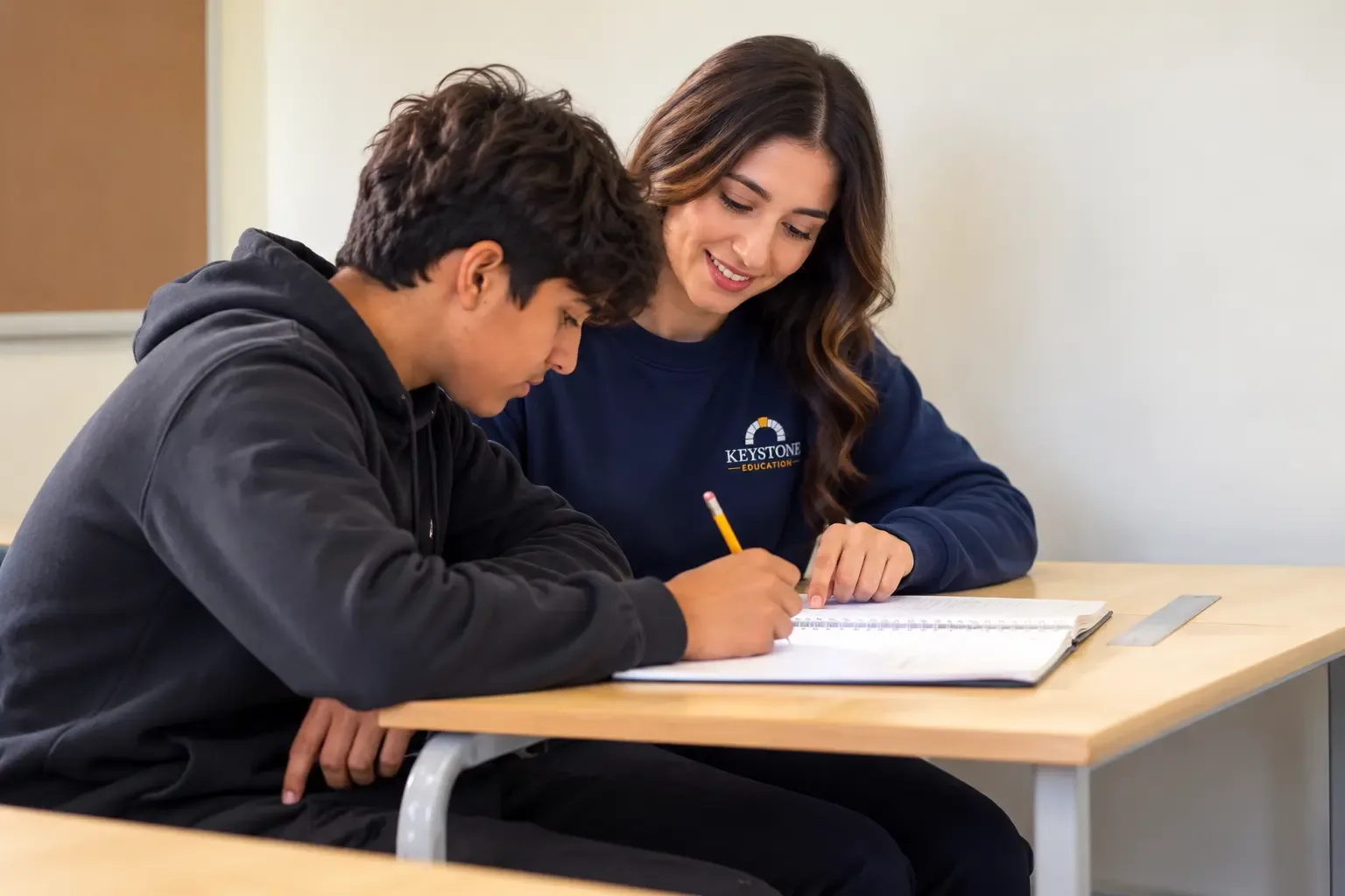 Tutor helping a student work through a notebook